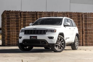 white jeep cherokee suv near stacked brown pallet boards